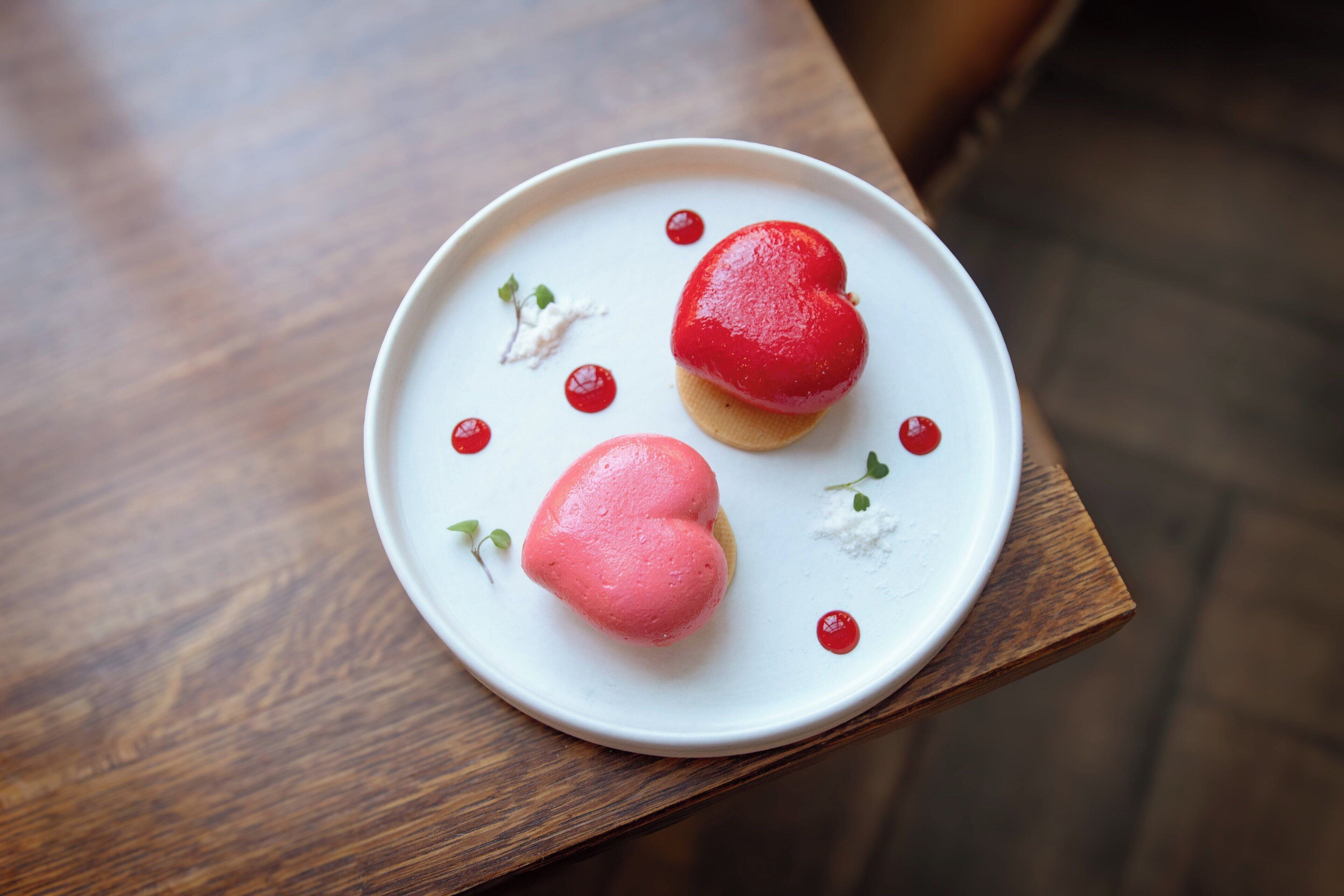 Un piatto con due dolcetti a forma di cuore su un piatto bianco.