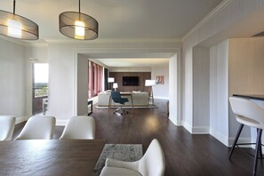 A modern hotel room with a dining area, a TV mounted on the wall, and a view of the outdoors. - Crowne Plaza Atlanta Perimeter at Ravinia by IHG (Atlanta)