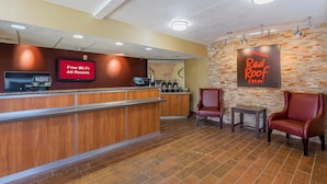 Zona de recepción de Red Roof Inn con mostrador de madera, señal de Wi-Fi gratuito y estación de café.