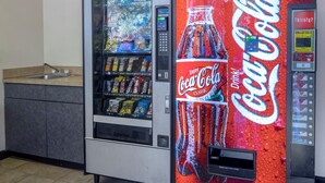 Máquina expendedora con logotipo de Coca-Cola y dispensador de agua.
