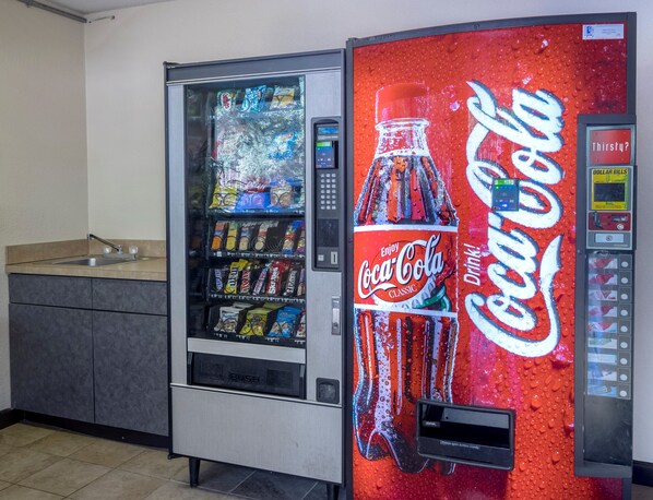 A vending machine with a Coca-Cola logo and a water dispenser.