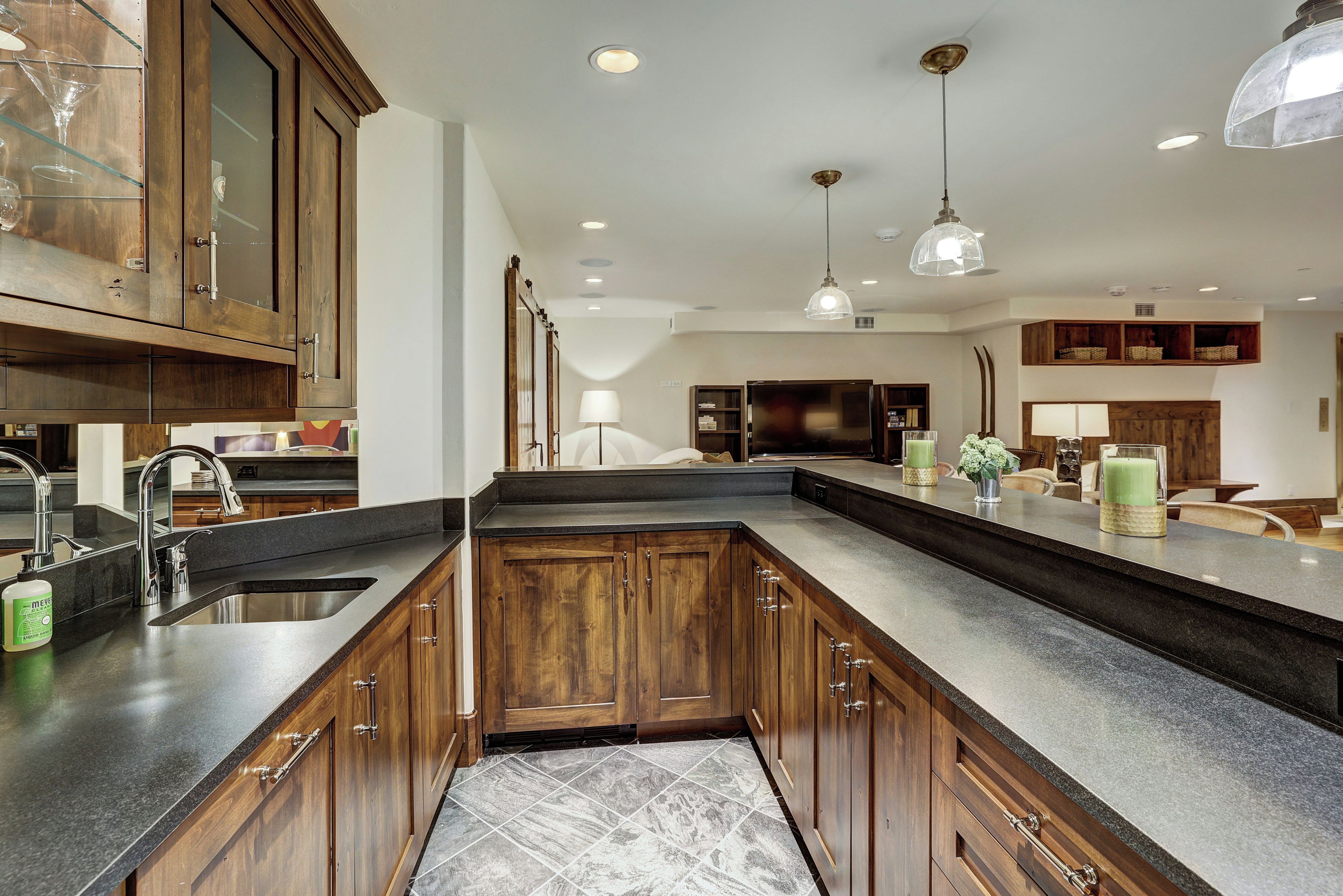 Una cocina con armarios de madera, encimera de mármol y un lavabo.
