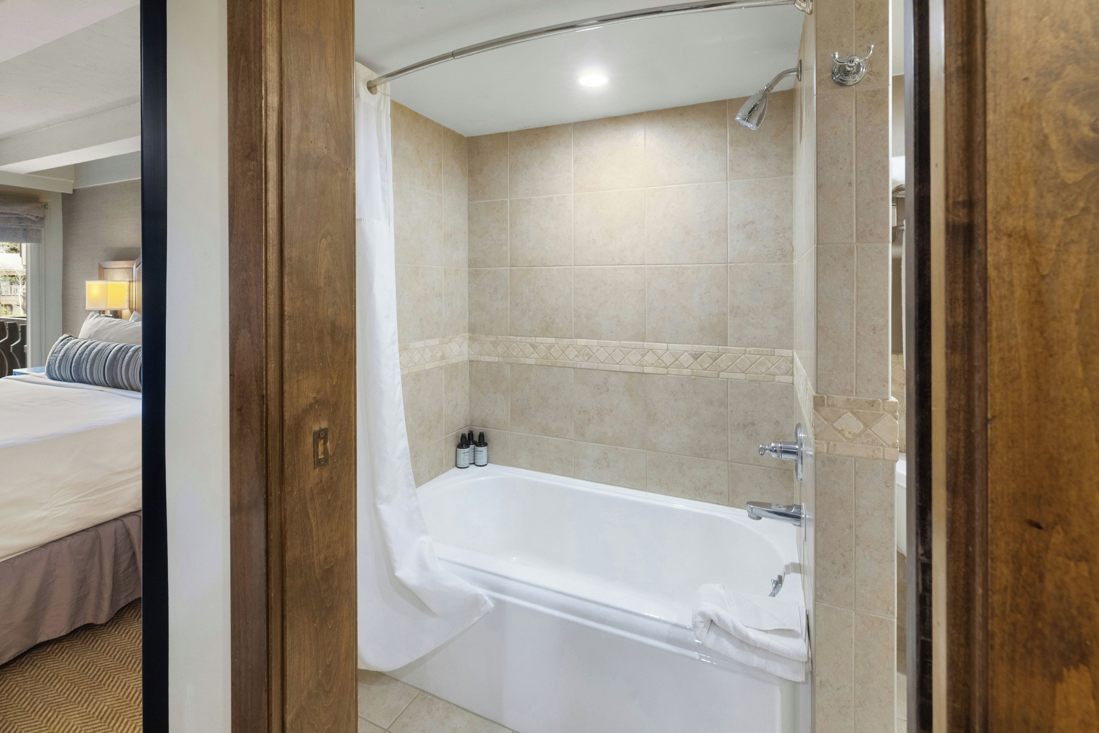 Une salle de bain d’hôtel équipée d’une baignoire, d’une douche et d’un porte-serviettes.