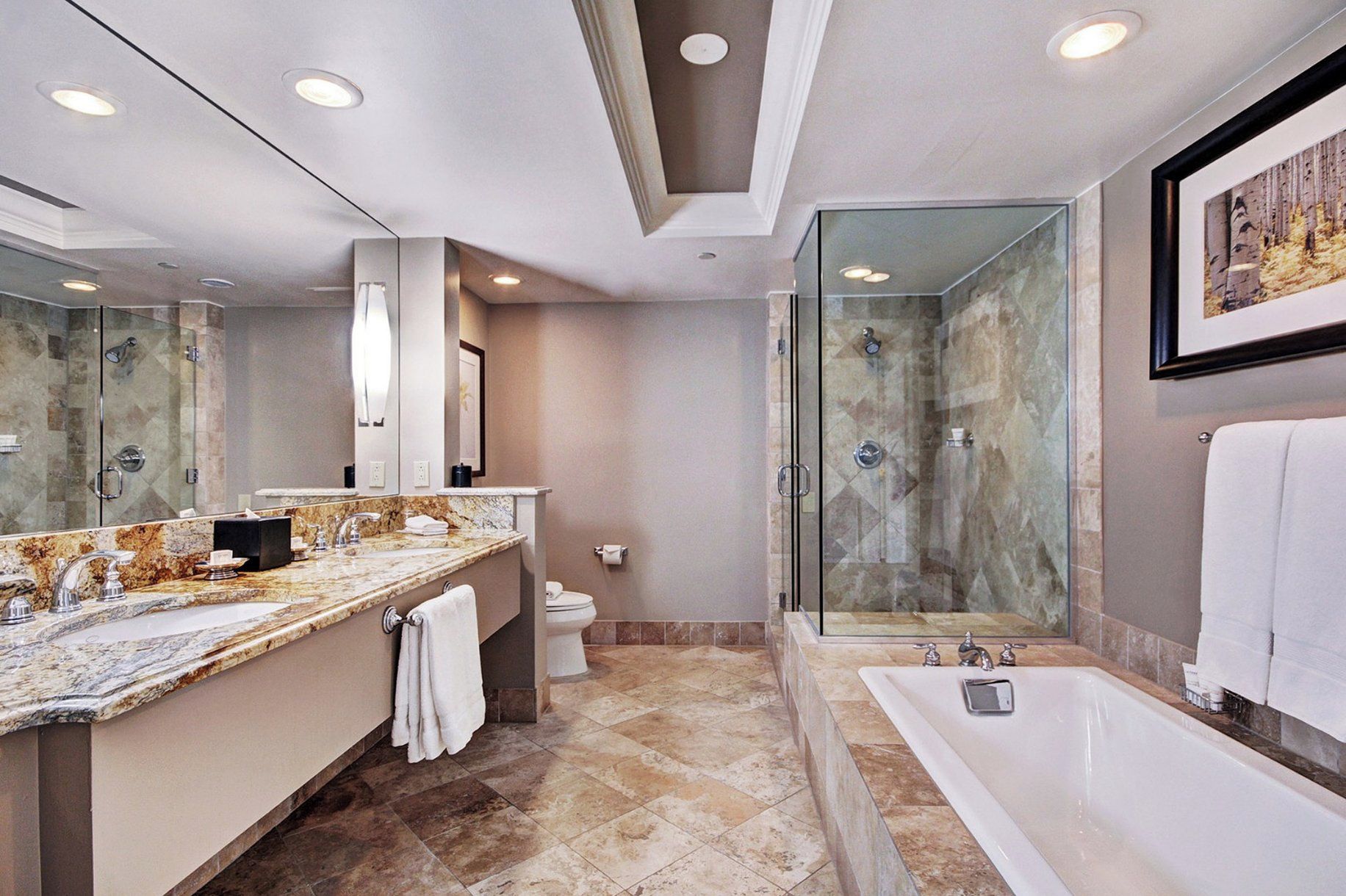 A modern bathroom with a large marble vanity, a separate shower area, and a bathtub.