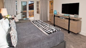 Un dormitorio moderno con una cama grande, un escritorio con televisor de pantalla plana y vistas al exterior.