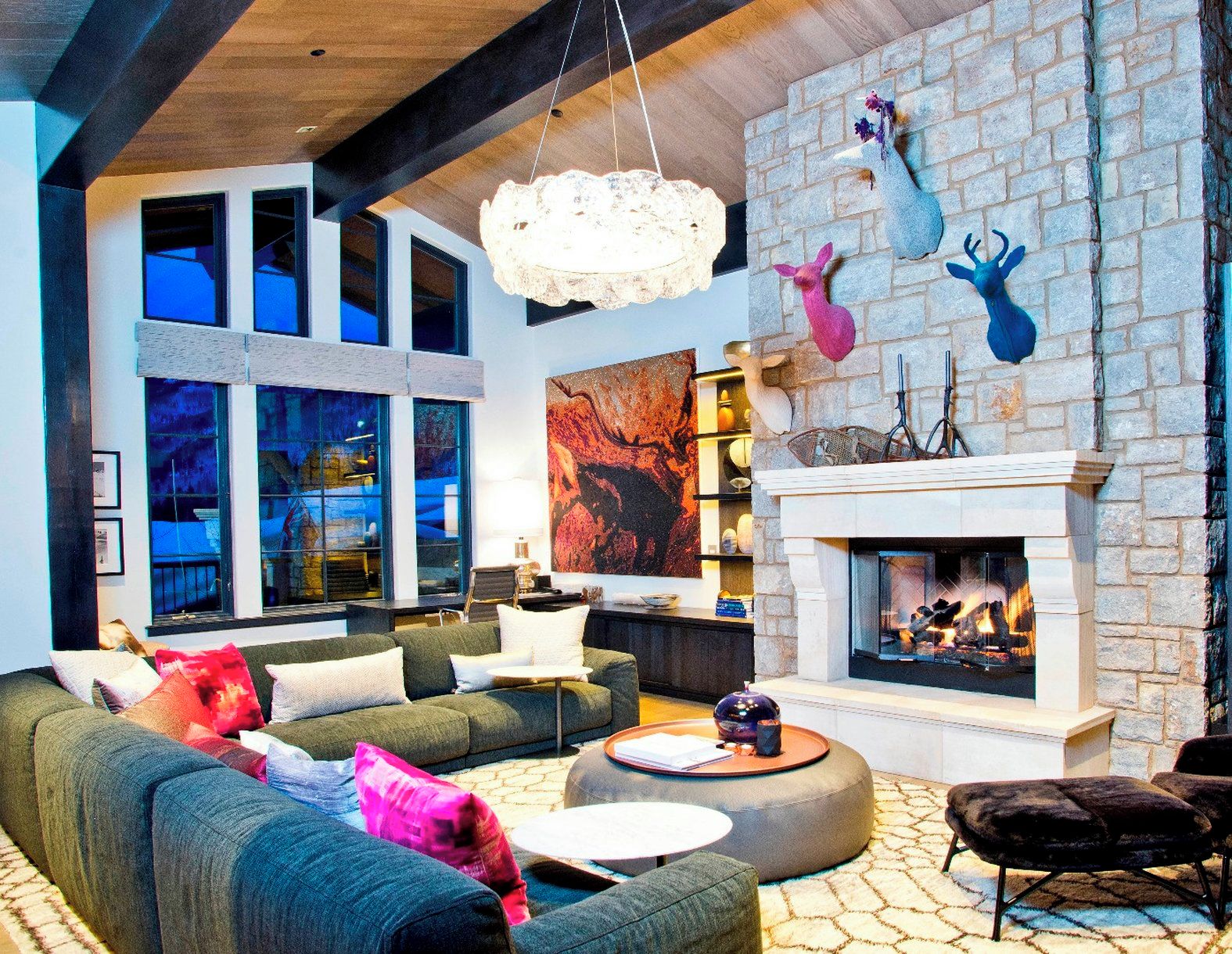 A modern living room with a fireplace, large windows, and a stone accent wall.
