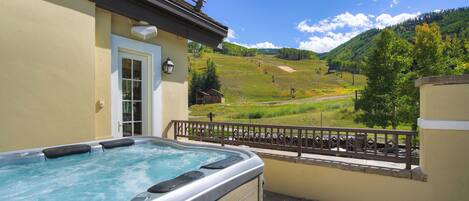 A hot tub on a balcony with a mountain view.
