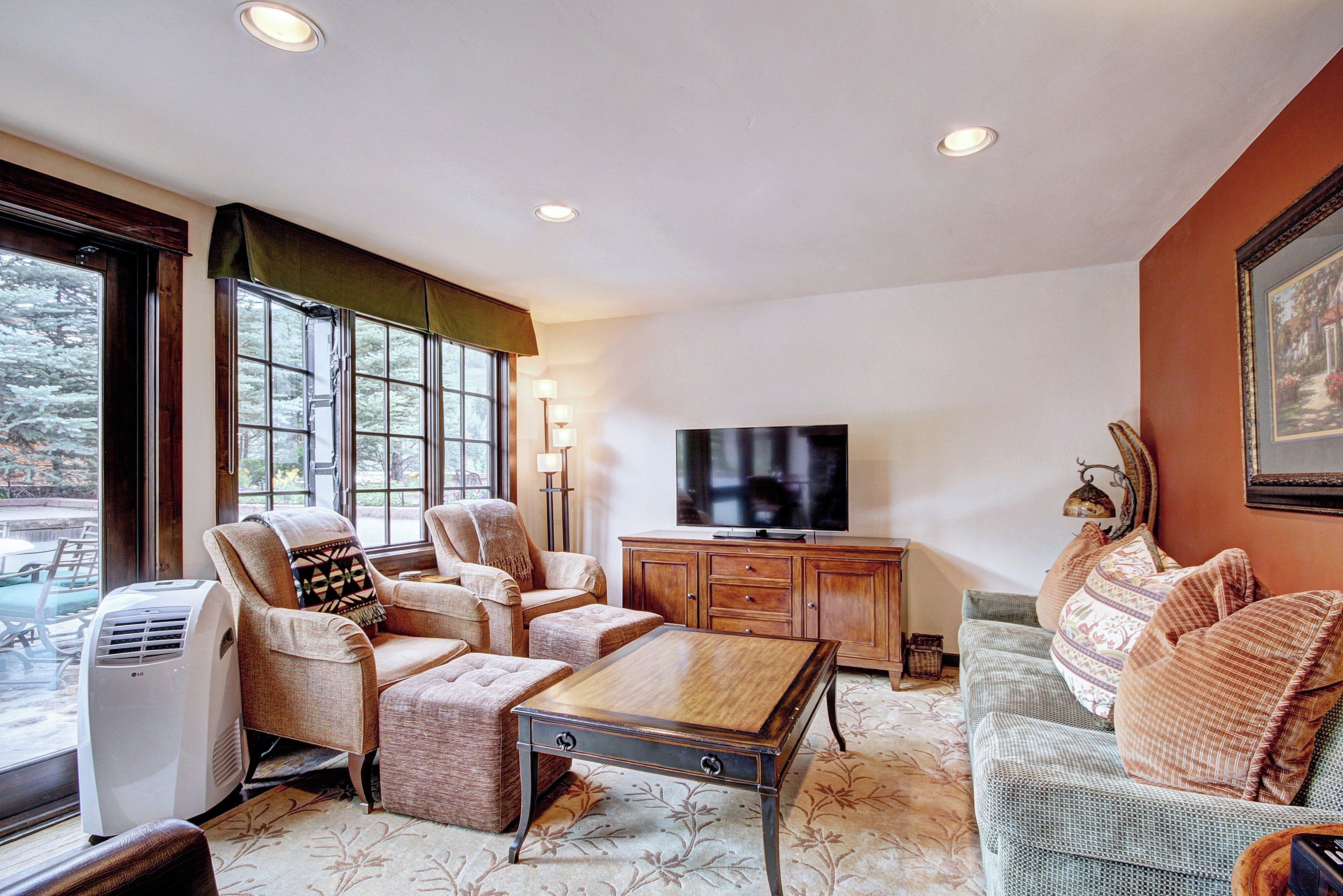 A living room with a large window, a television, and a fireplace.