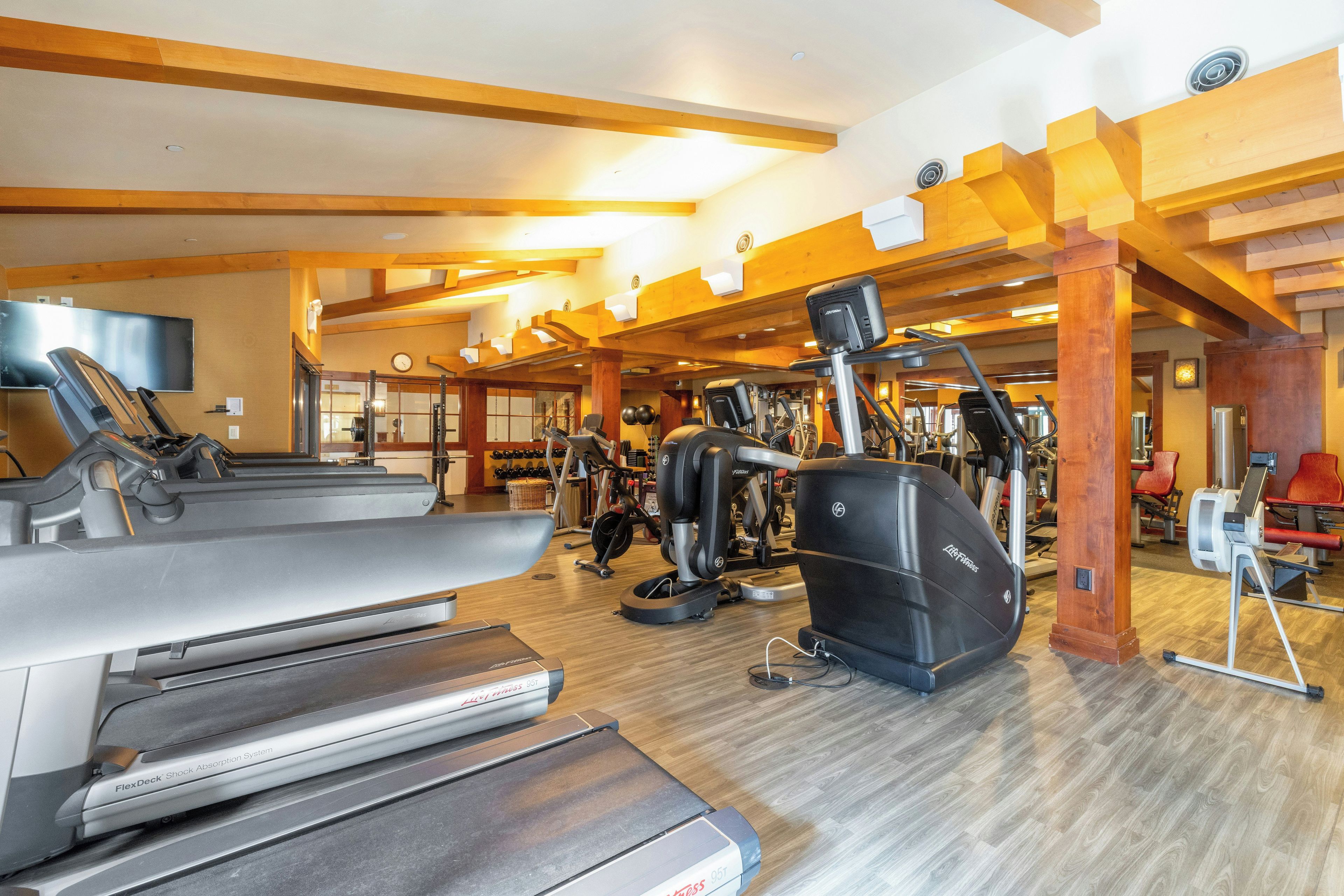 A gym with treadmills, elliptical machines, and weight equipment.