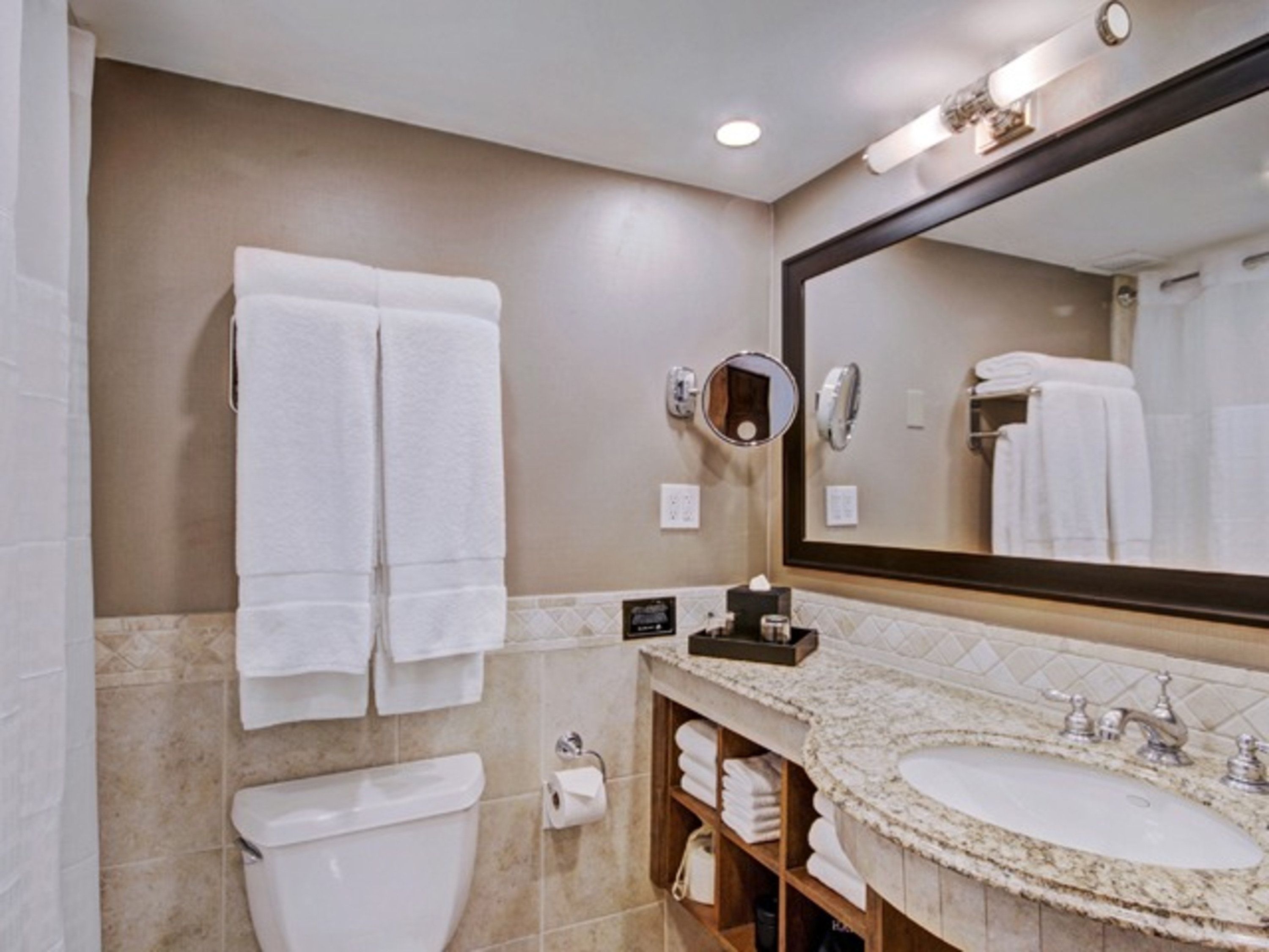 A bathroom with a toilet, sink, and towel rack.