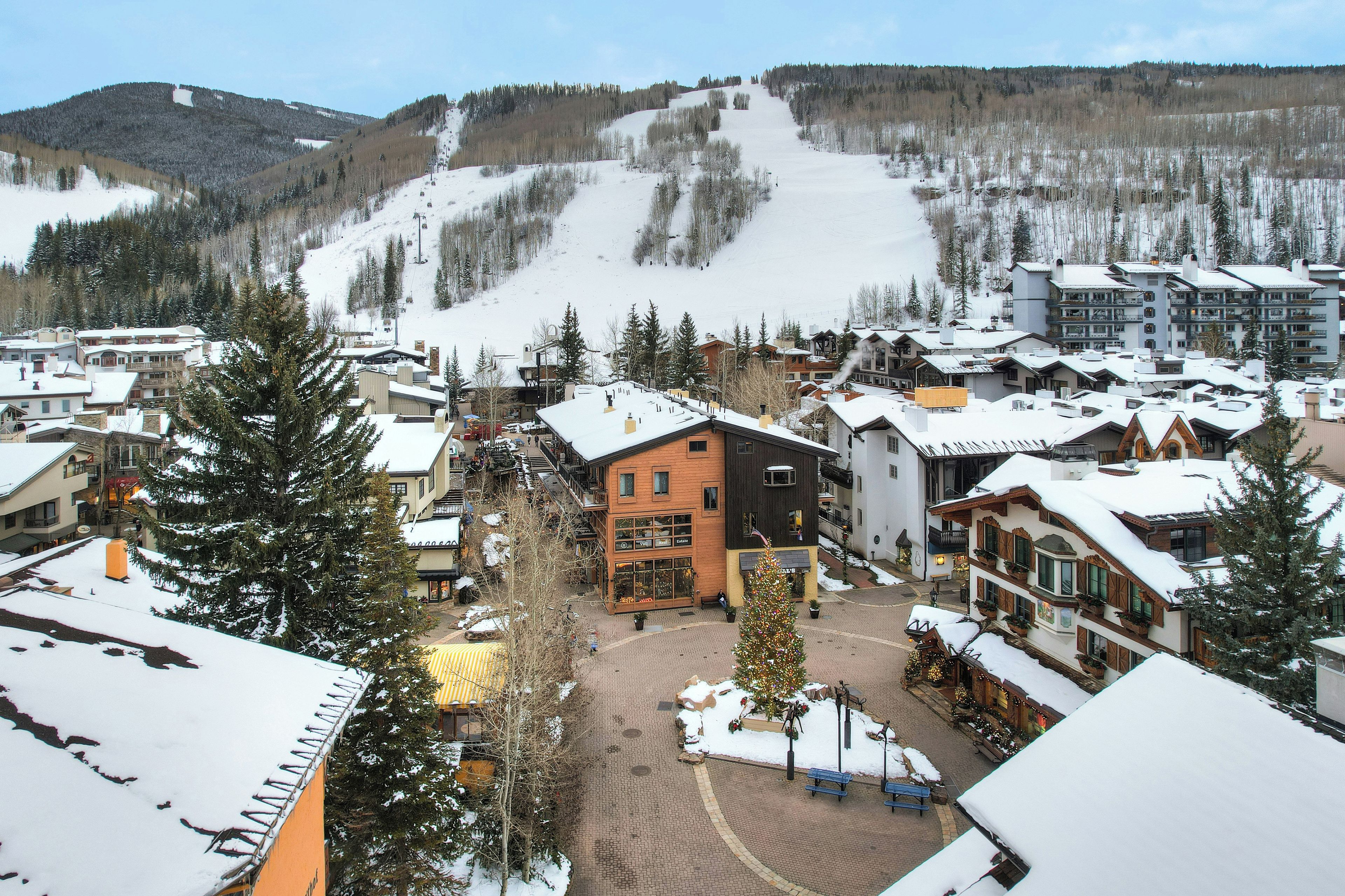 Ein Skigebiet mit Gebäuden, einer schneebedeckten Piste und einem Ortszentrum.