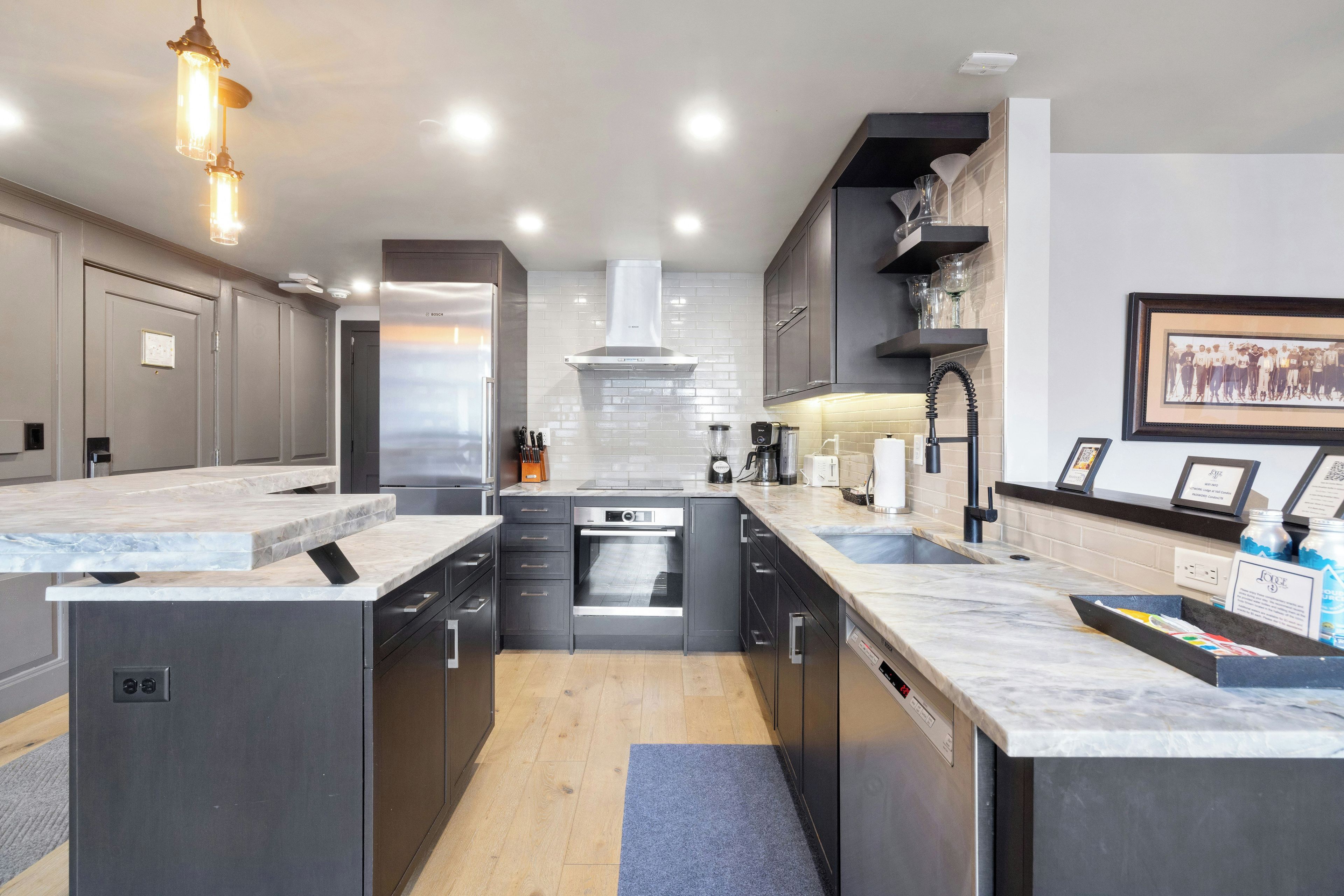 A modern kitchen with a central island, built-in appliances, and a backsplash.