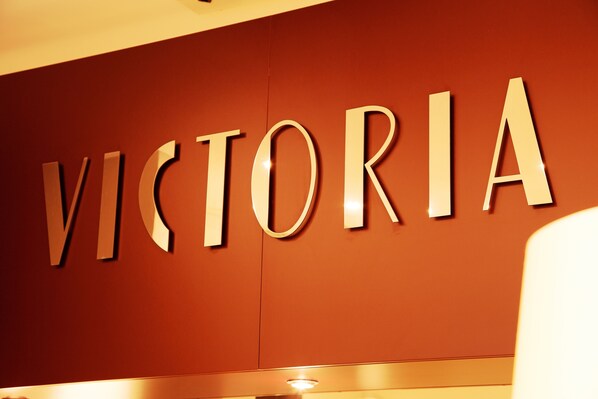 Una pared con la palabra 'VICTORIA' en letras metálicas grandes.