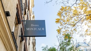Un cartel anuncia el Hotel Montcalm, con una vista clara de la fachada del edificio y los árboles circundantes.