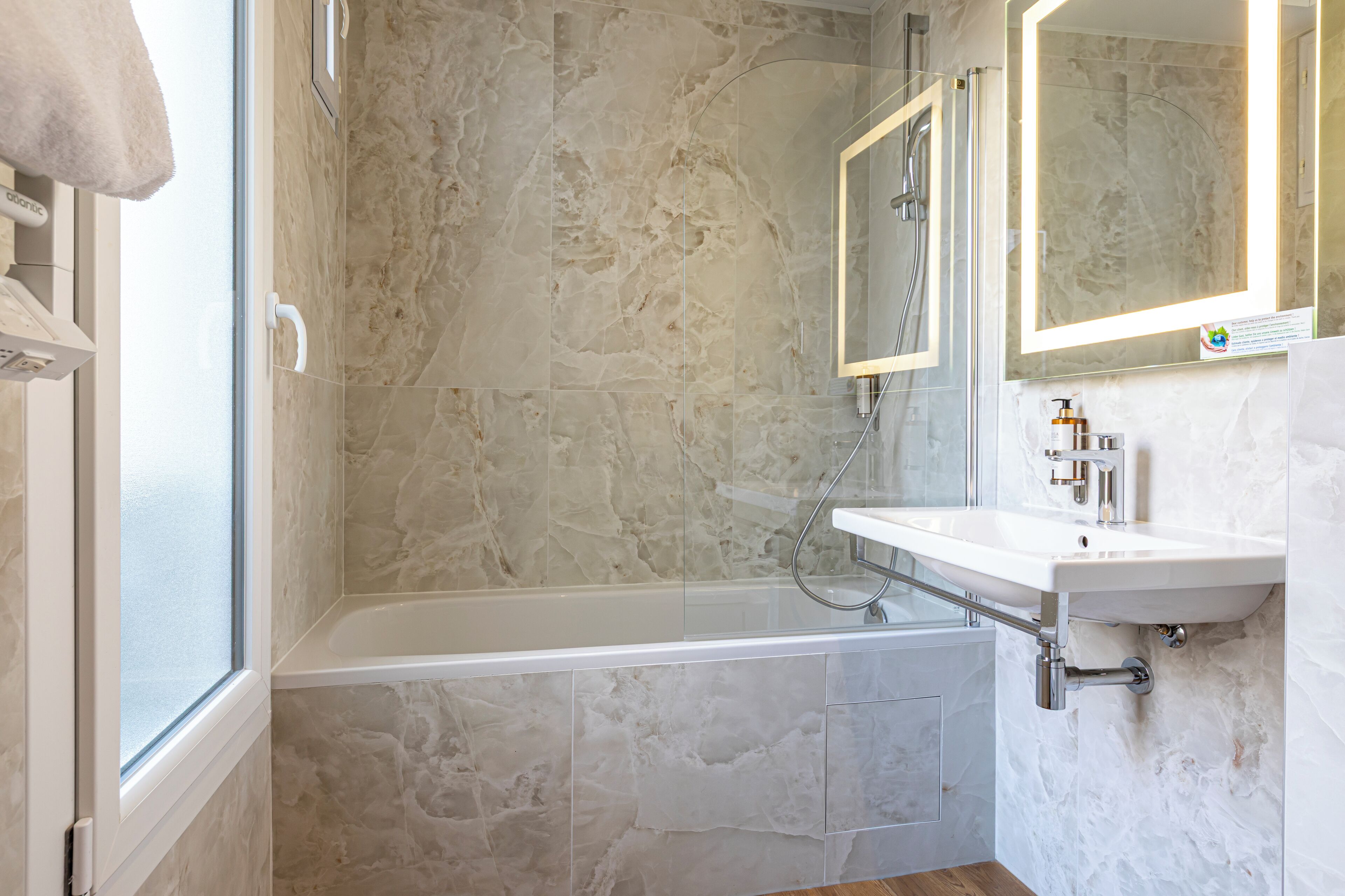 A modern bathroom with a bathtub, a shower, and a sink.