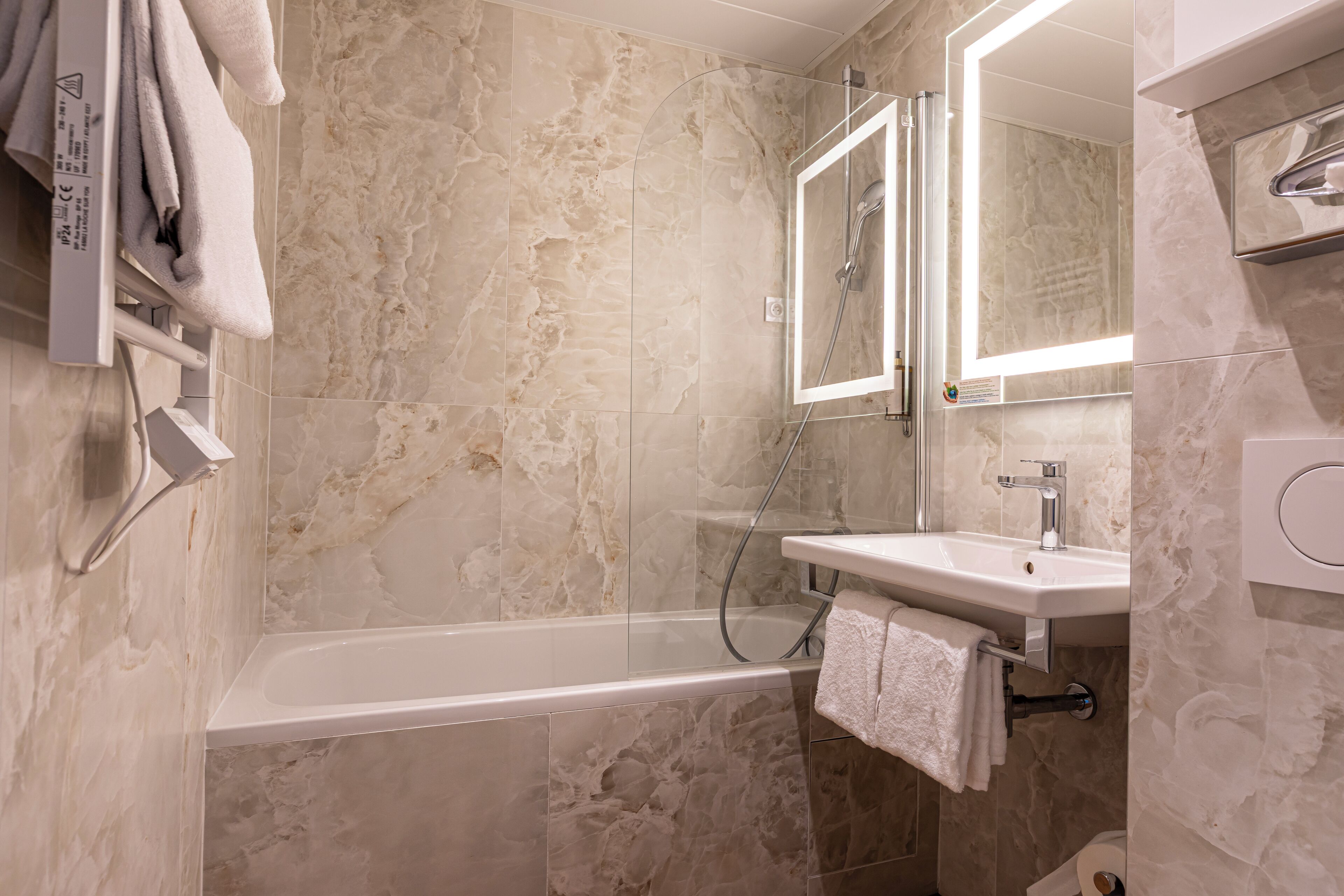 Un baño moderno con bañera, lavabo y espejo.