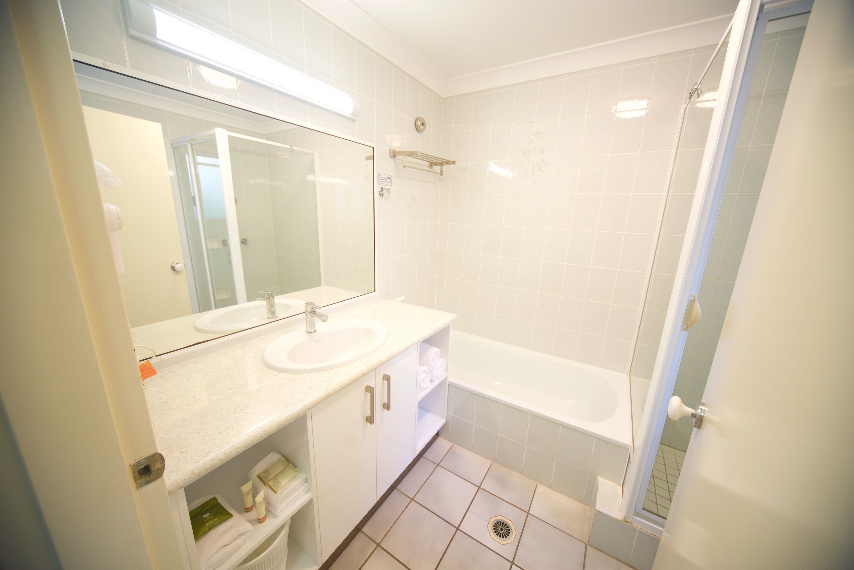 A modern bathroom with a sink, mirror, and bathtub.