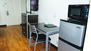A compact kitchenette with a refrigerator, microwave, and a small dining table with chairs. - Stay Express Inn Dallas - Fair Park / Downtown (Dallas)