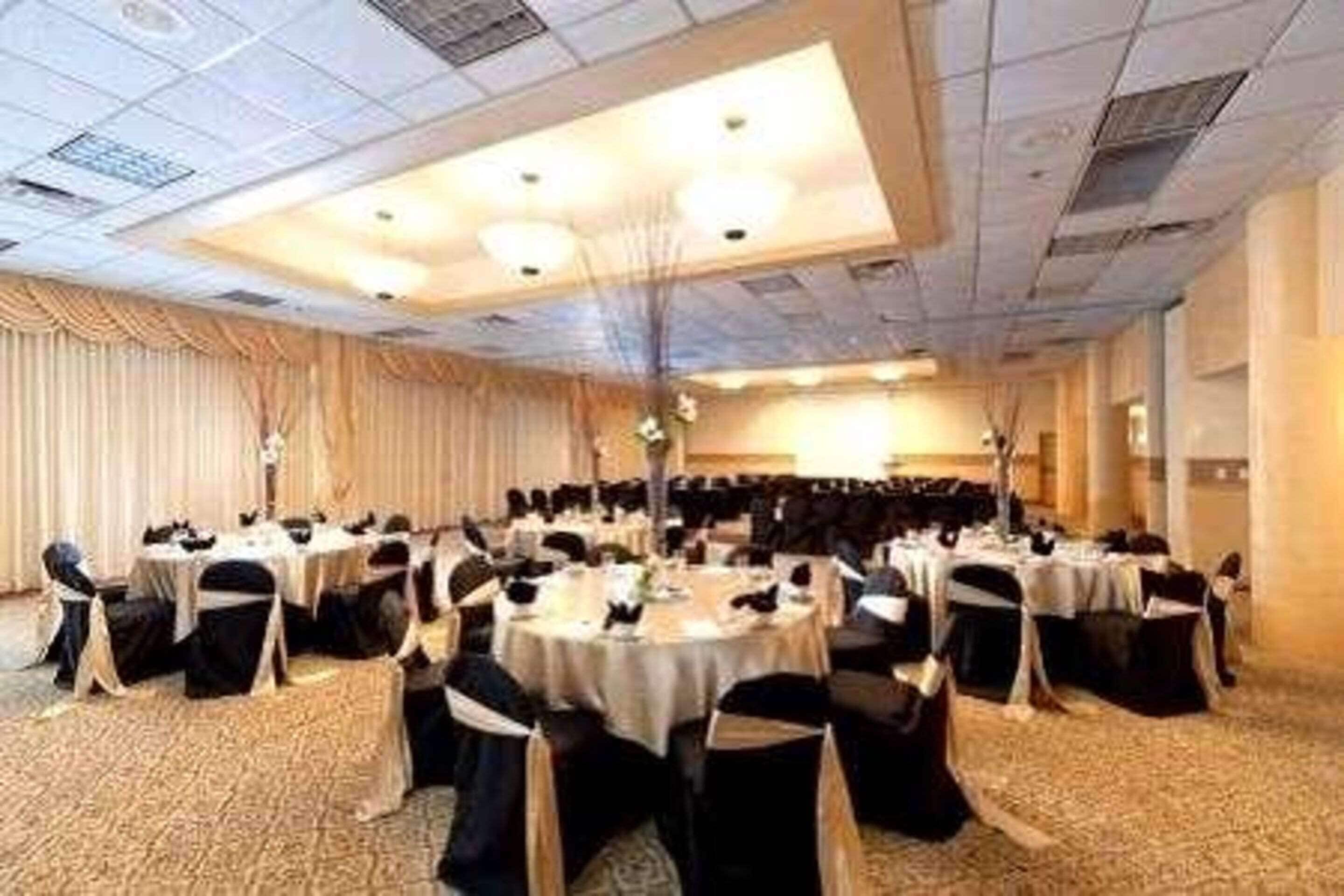 A conference room with round tables and chairs, arranged for a meeting or event.