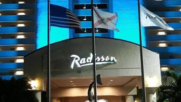 Un hôtel Radisson doté d’une entrée imposante, d’un drapeau et d’une fontaine.