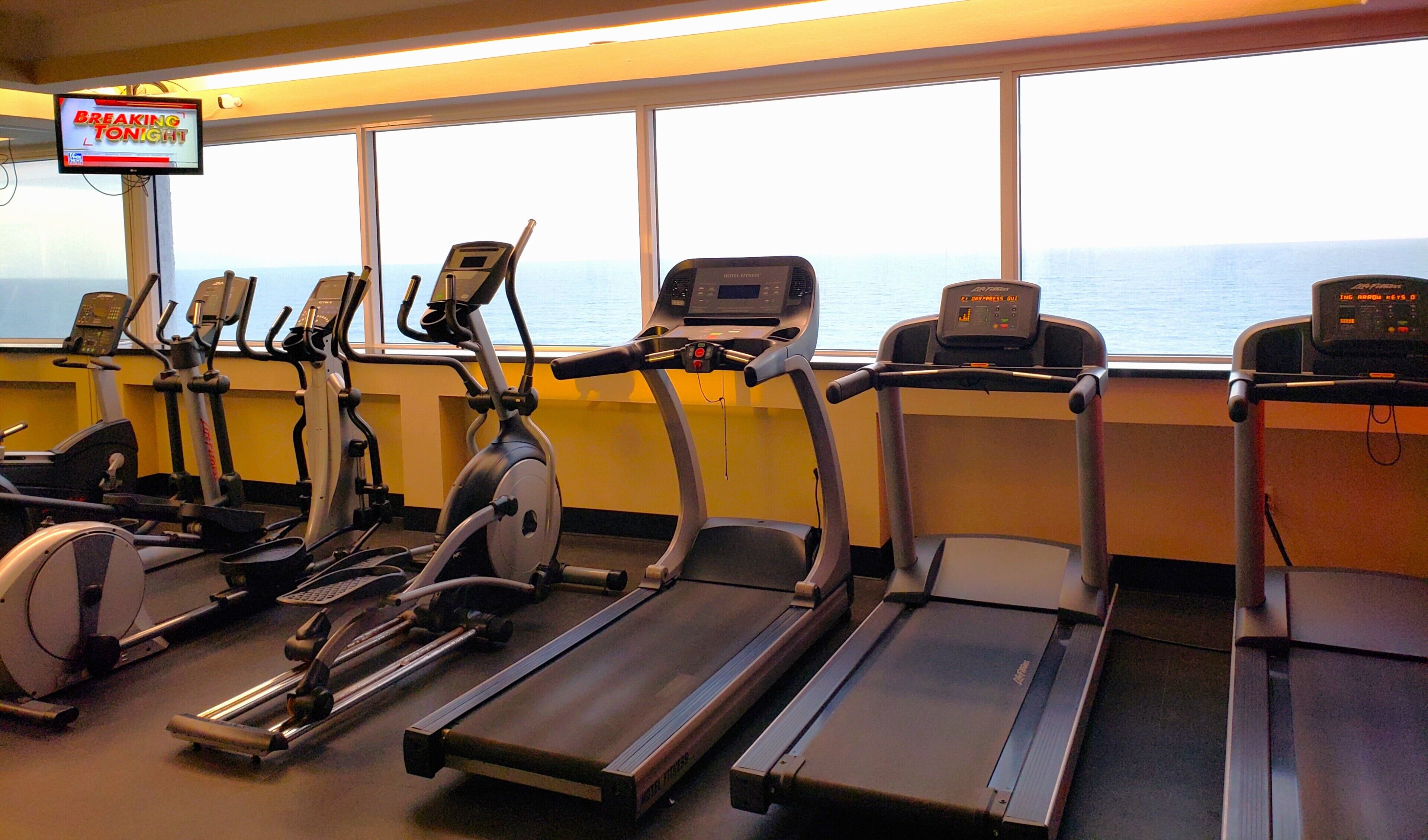 Ein Fitnessstudio mit Laufbändern, Ergometer und Crosstrainern.