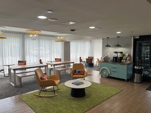 Ein modernes Hotelzimmer mit Essbereich, Sitzgelegenheiten und einer Küchenzeile.
