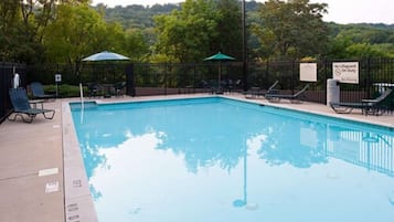 Una piscina al aire libre de temporada, sillones reclinables de piscina