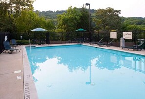 Una piscina al aire libre de temporada, sillones reclinables de piscina