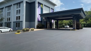Un bâtiment moderne doté d’une entrée couverte et d’un parking.