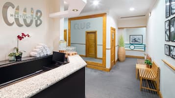 A reception area with a counter, a mirror, and a door leading to a room.