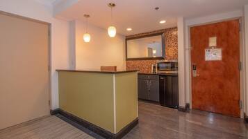 A hotel reception area with a reception desk, a microwave, and a wooden door.