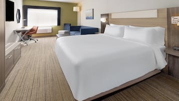 Una habitación de hotel con una cama grande, un escritorio con una silla, un sofá y un televisor.
