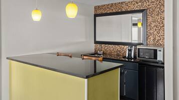 A modern kitchen with a central island, a microwave, and a sink.