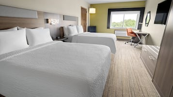 A hotel room with two beds, a desk, and a chair.
