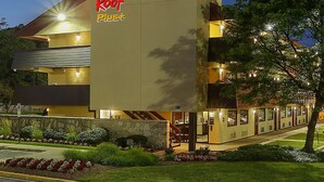 A hotel with a prominent Red Roof Plus sign, a stone facade, and a well-lit entrance. - Red Roof Inn PLUS+ Washington DC - Oxon Hill (Oxon Hill)
