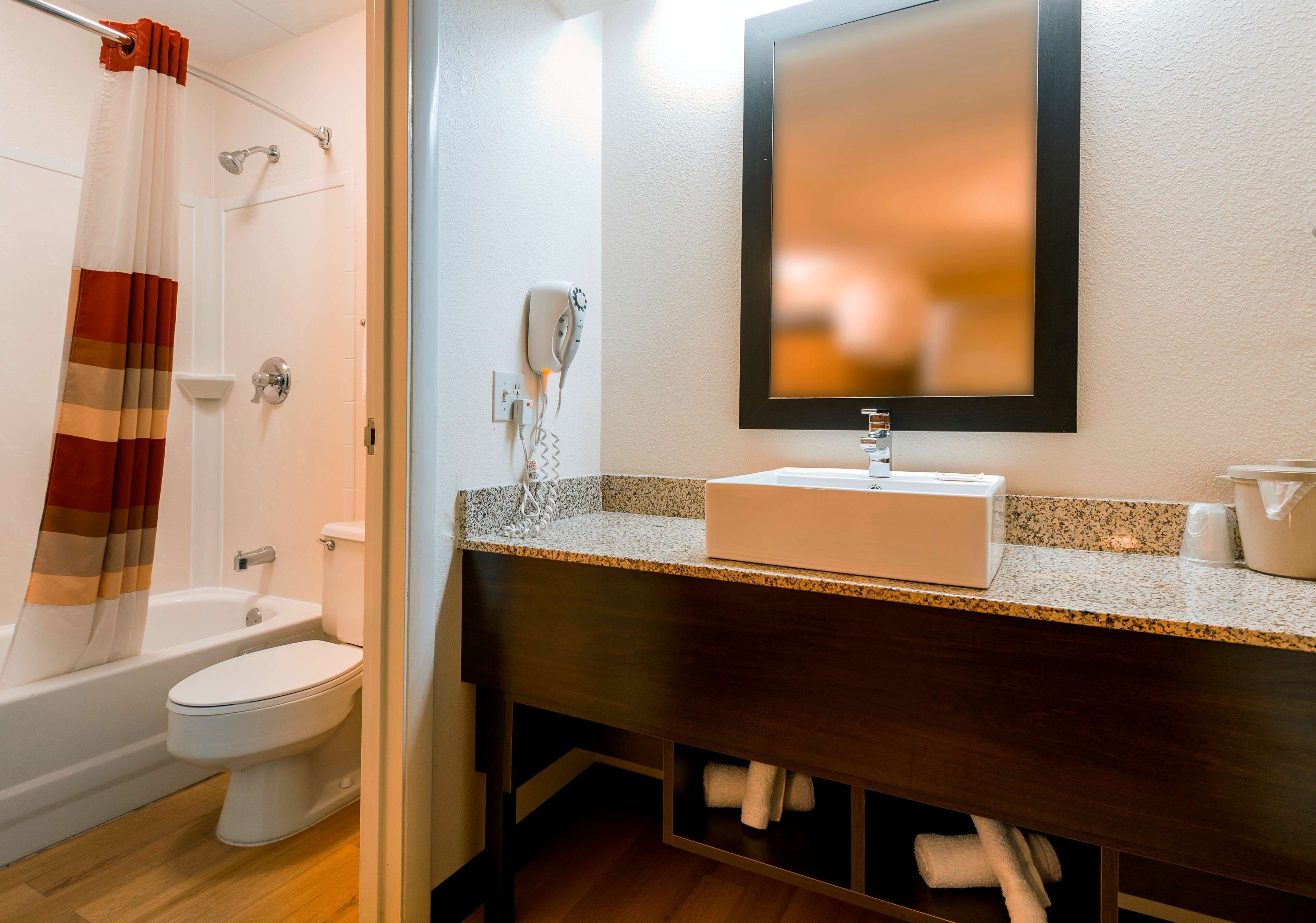 Une salle de bain équipée d’une douche, de toilettes, d’un lavabo et d’un espace pour ranger les serviettes.