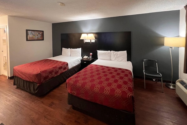 A hotel room with two beds, a nightstand with a lamp, a chair, and a picture on the wall. - Econo Lodge Inn & Suites Tuscaloosa I-20 (Tuscaloosa)