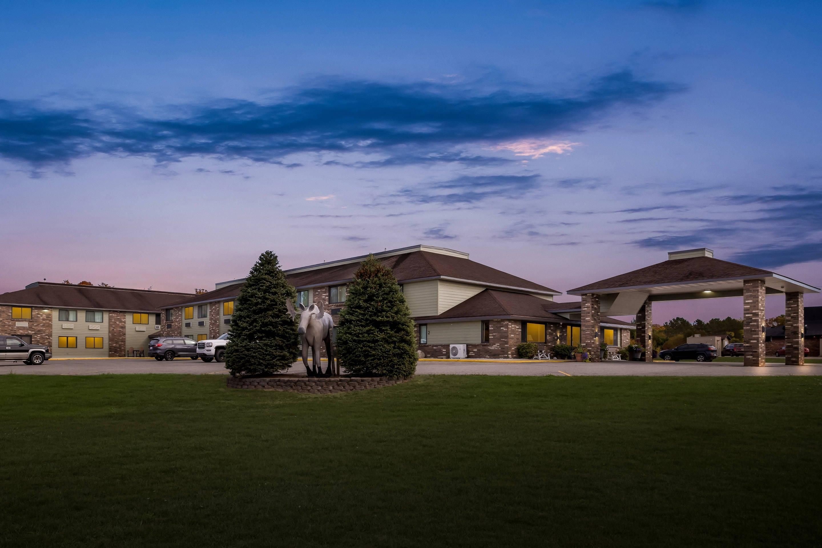 A hotel with a central courtyard, a fountain, and a covered parking area.
