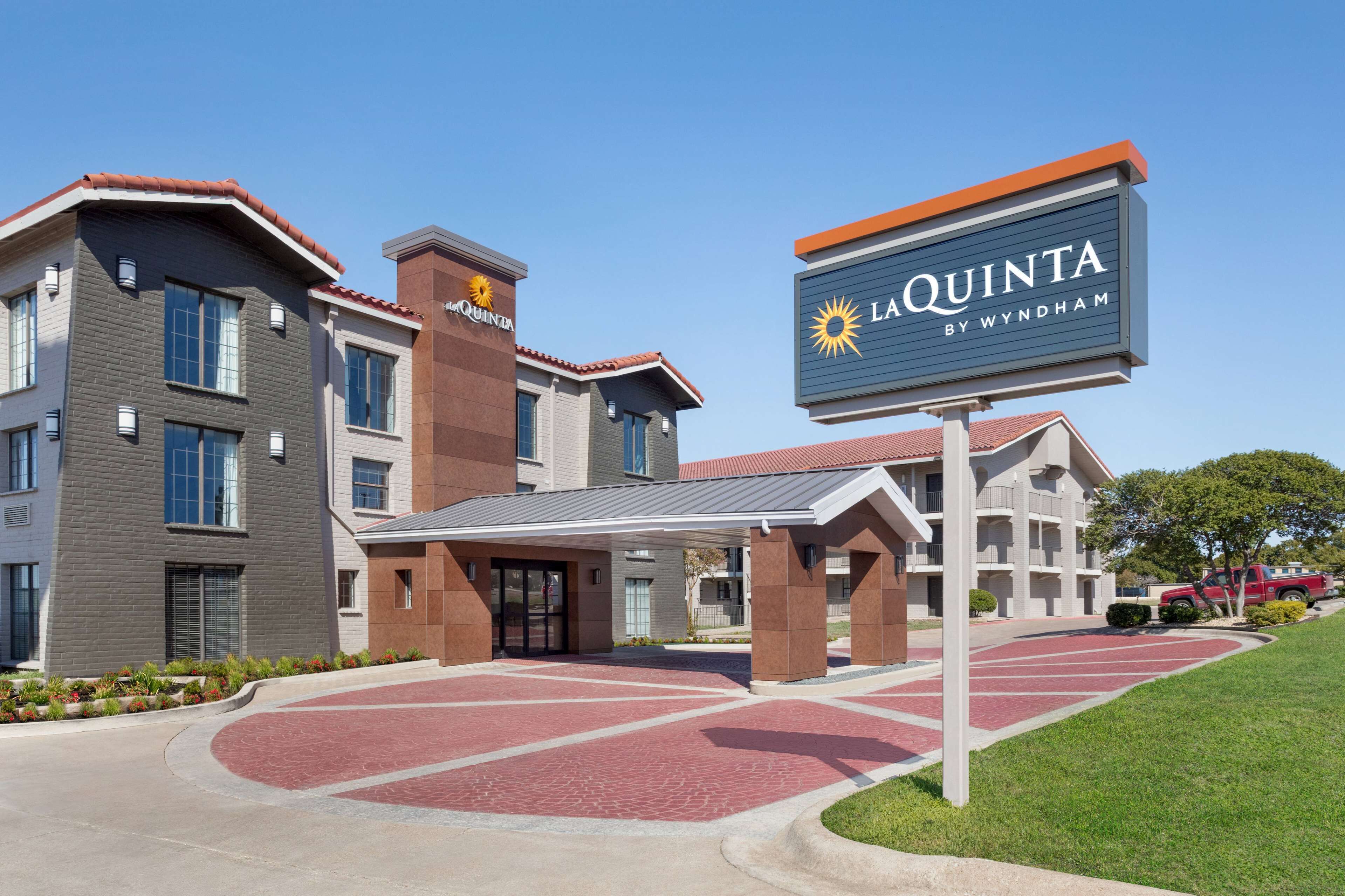 Un hôtel au design moderne, avec une enseigne bien visible indiquant « La Quinta by Wyndham ».