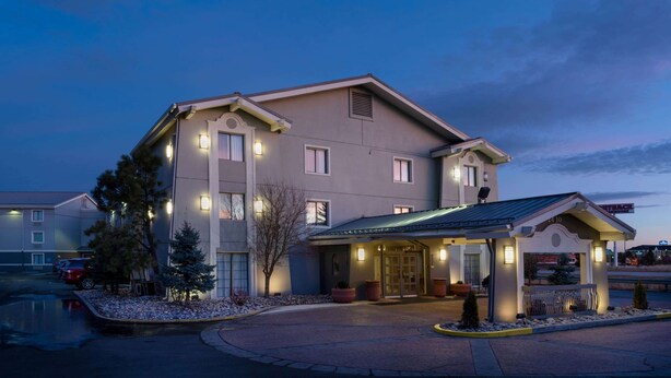 A multi-story hotel with a covered entrance and a parking area.
