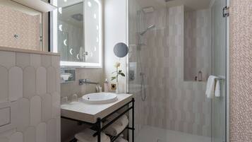 Une salle de bain moderne avec une douche à parois de verre, un meuble-lavabo et un grand miroir.