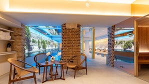 A modern lounge area with a pool view, stone walls, and wooden furniture. - Hôtel Astra Opéra - Astotel (Paris)