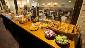 A buffet setup with various food items and a coffee station. - Hospitality Carnarvon, SureStay Collection by Best Western (South Carnarvon)