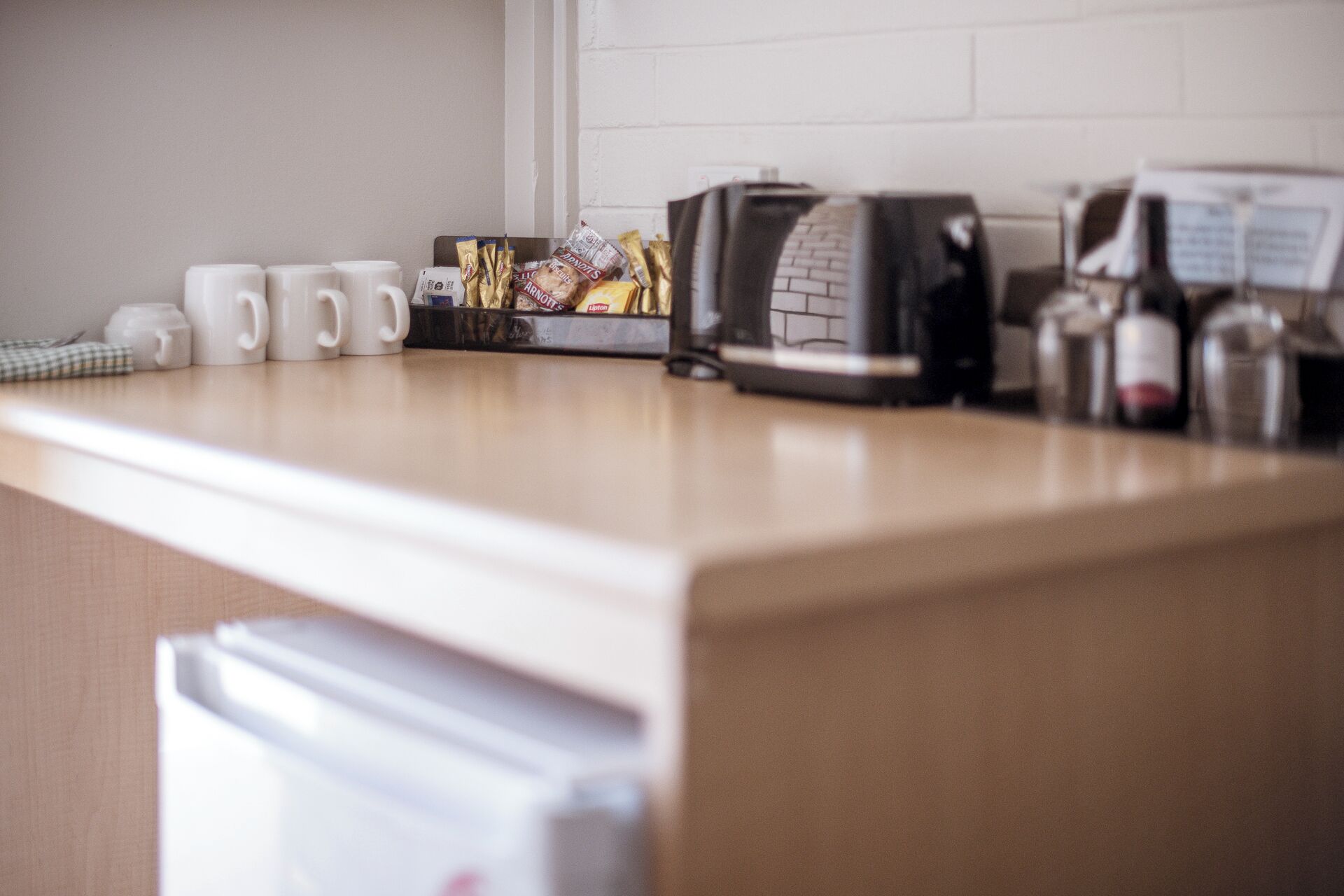 A kitchen counter with a coffee machine, a toaster, and a box of snacks.