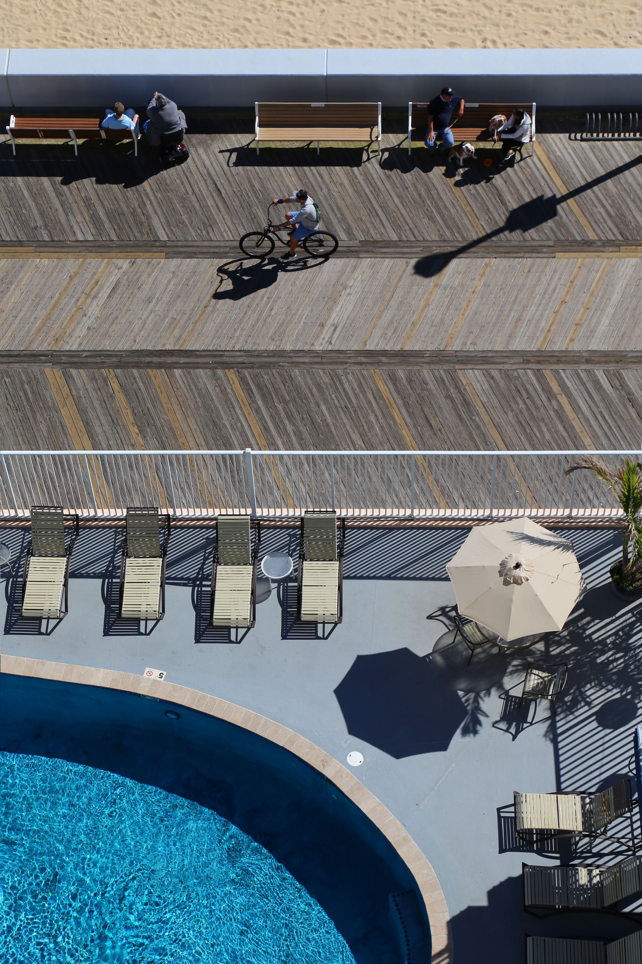 Un área junto a la piscina con terraza de madera, sillas de descanso y una pileta.