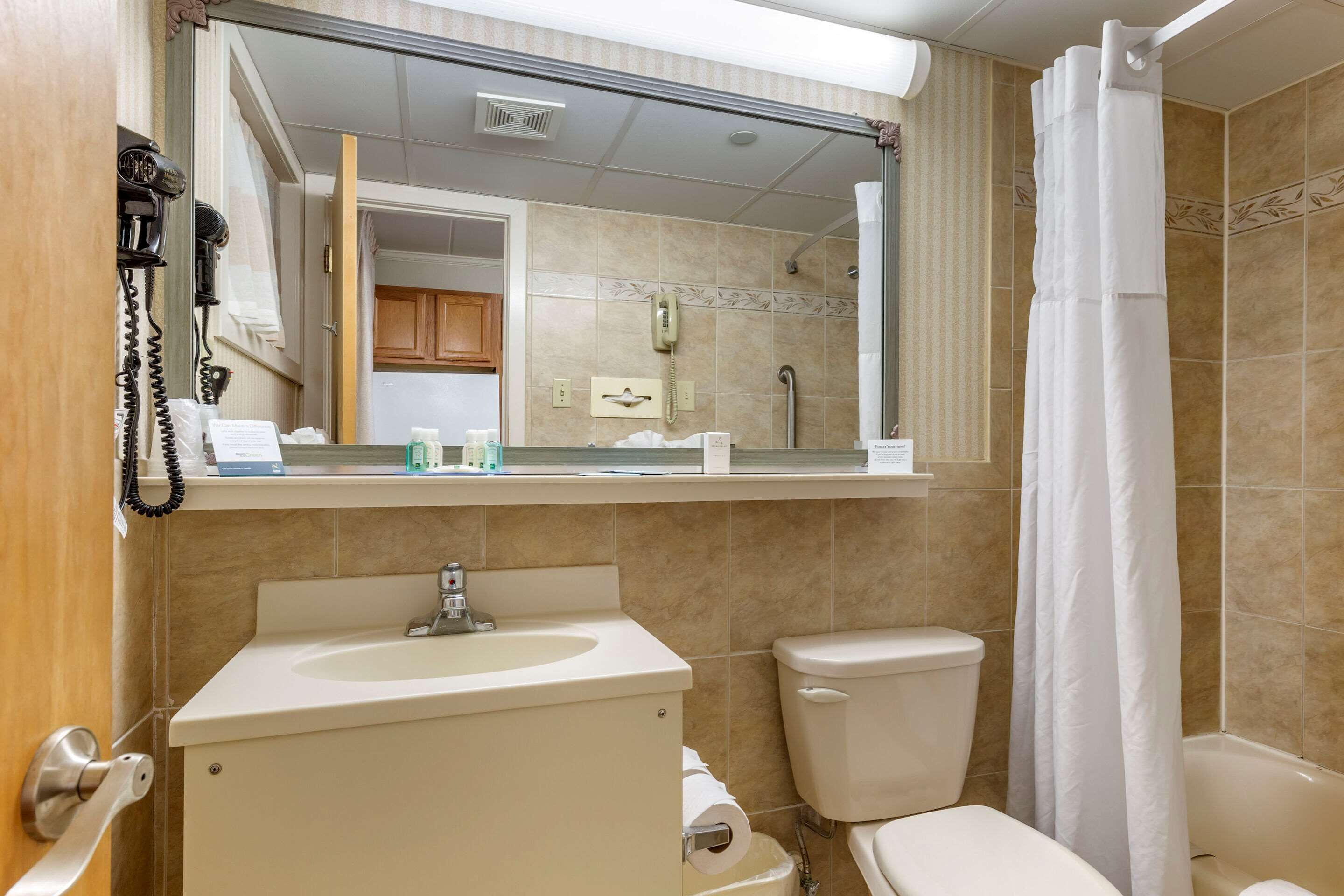 A bathroom with a sink, toilet, and shower curtain.