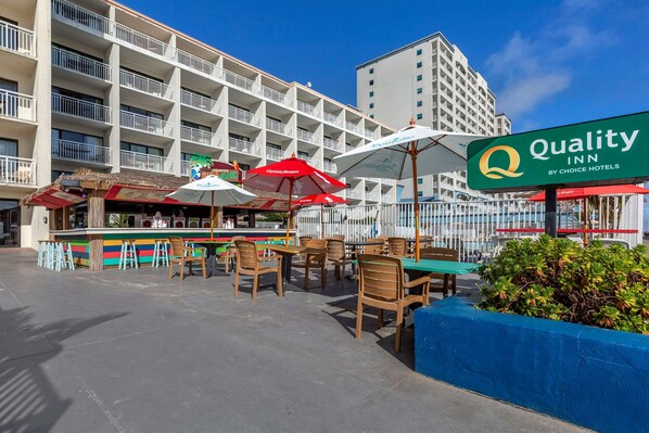 Un hôtel doté d’une terrasse, d’une enseigne « Quality Inn » et d’un espace piscine.