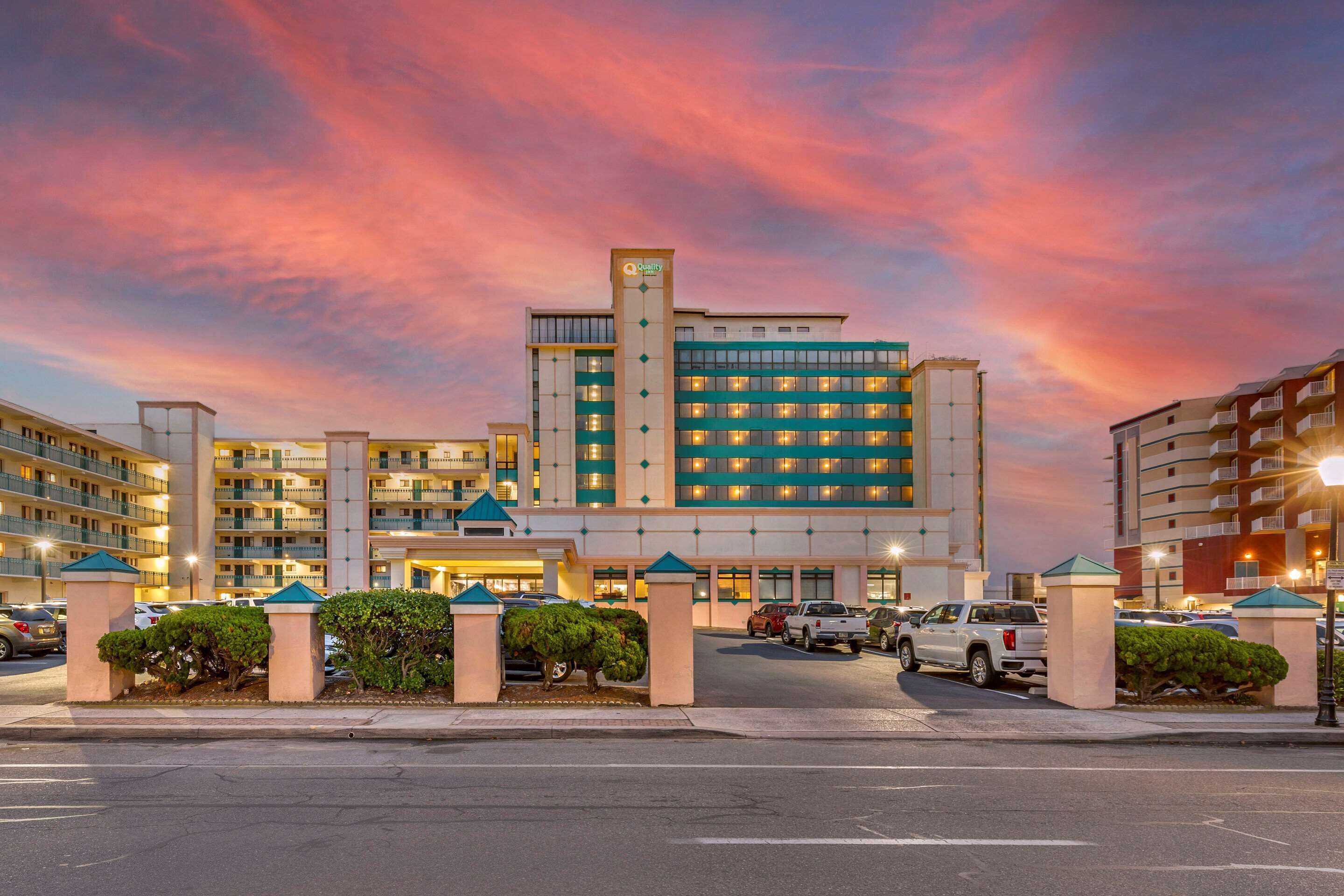 A hotel with multiple floors, a prominent entrance, and a parking area.