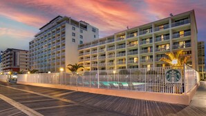 A hotel with multiple floors, balconies, and a swimming pool area. - Quality Inn Boardwalk (Ocean City)