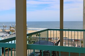 Ein Balkon mit Blick auf den Strand, ausgestattet mit Tisch und Stühlen sowie einem Geländer.